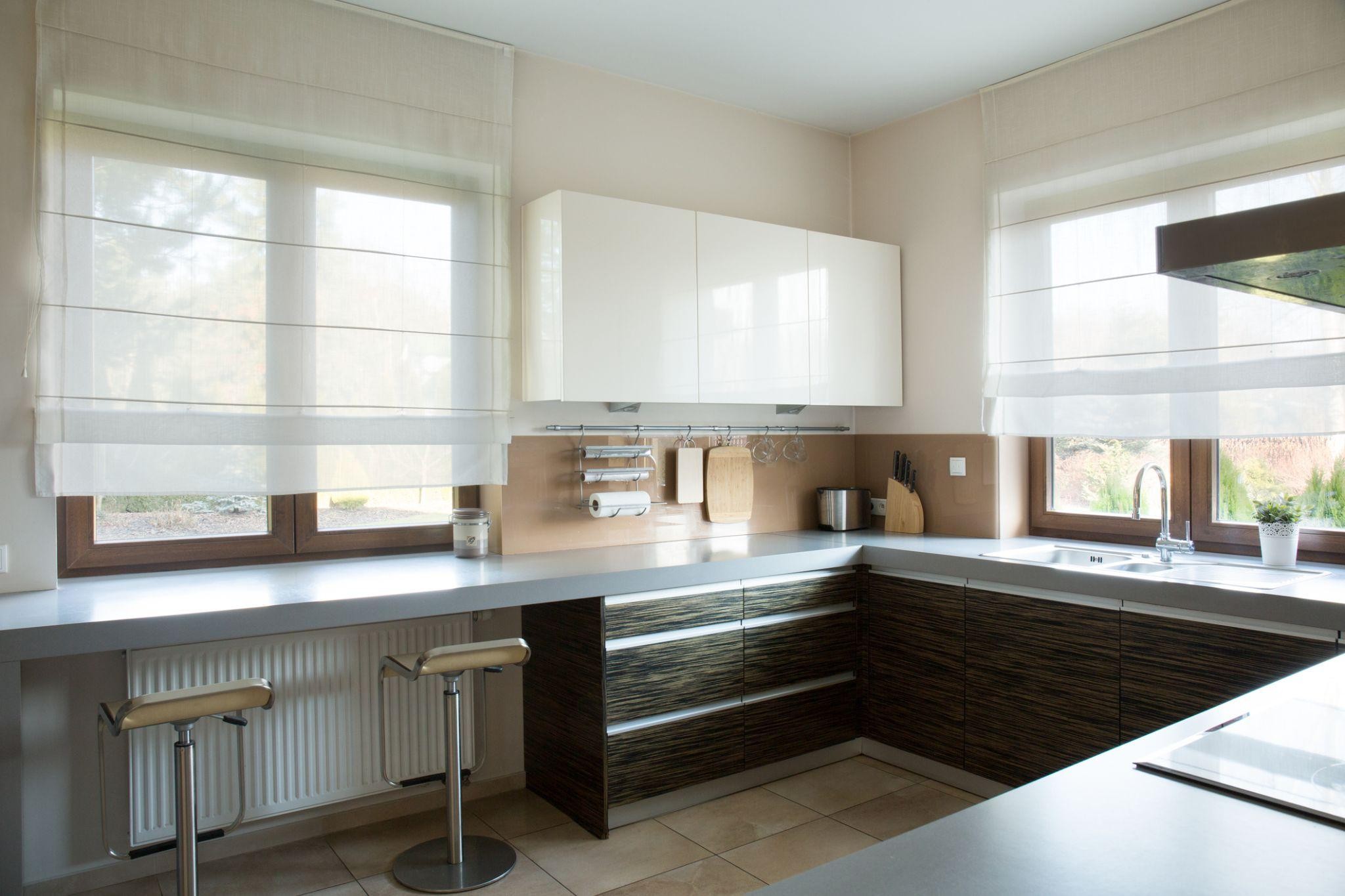 A modern kitchen with custom window shades that enhance the space's natural light